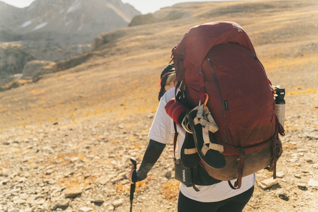Hiker with large backpack on a rocky mountain trail