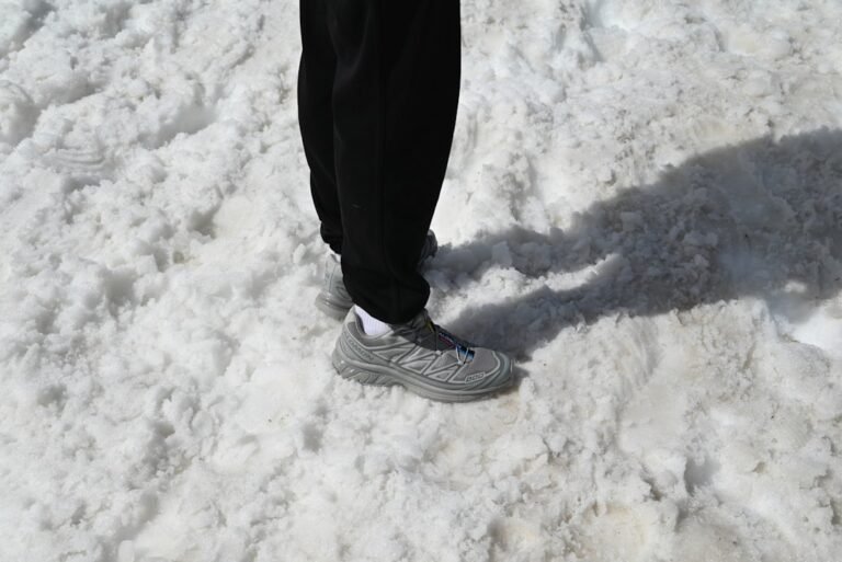 A person's feet standing on snow